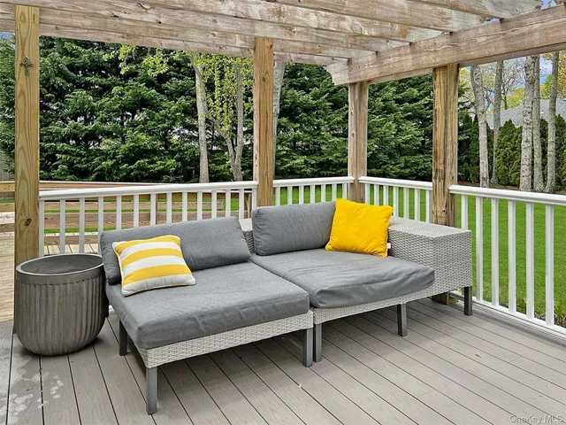 a balcony with wooden floor and outdoor seating