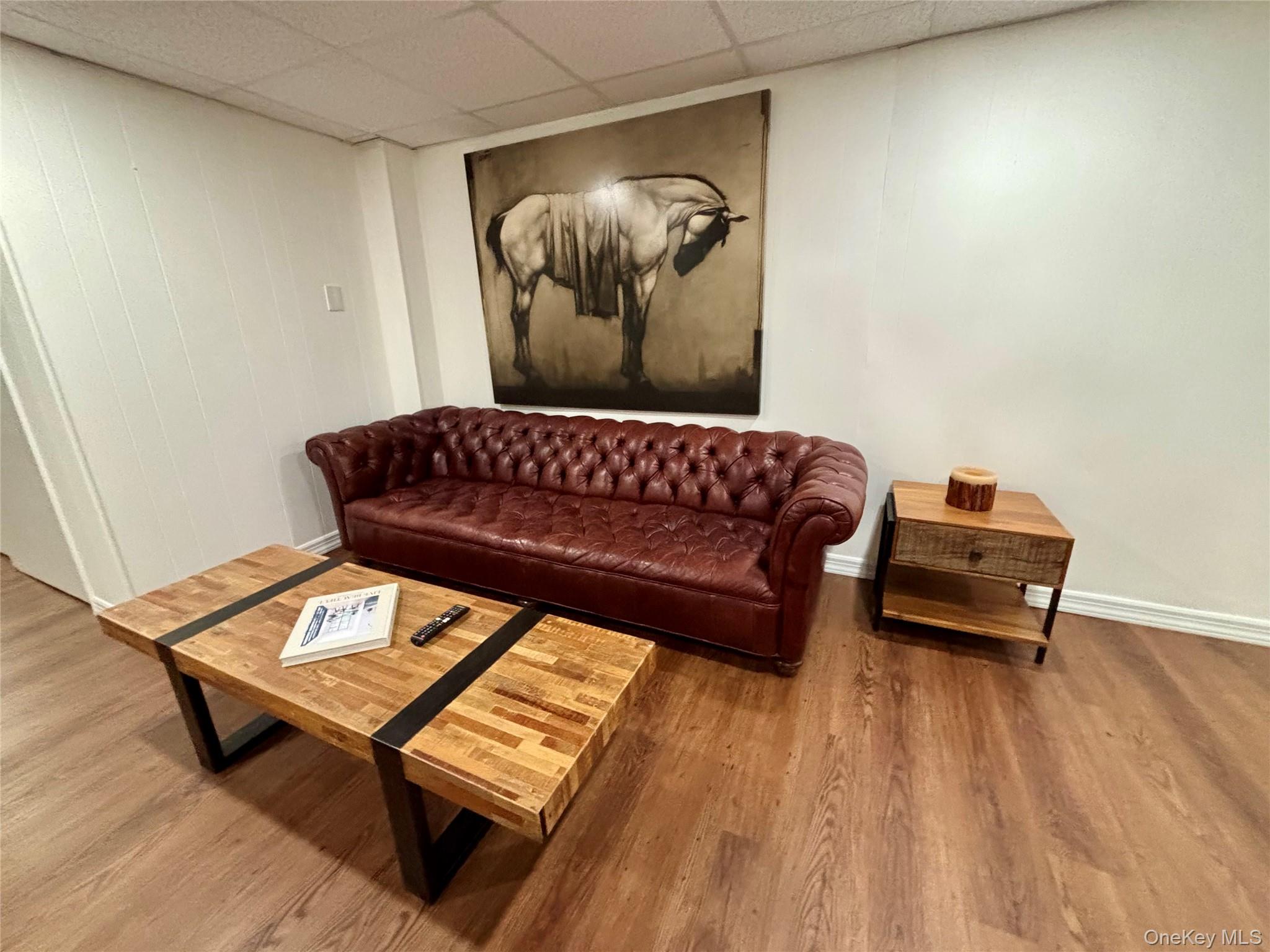 129 Lynncliff Road Hampton Bays, NY 11946 - Photo 19 of 24 a living room with a couch and a wooden floor
