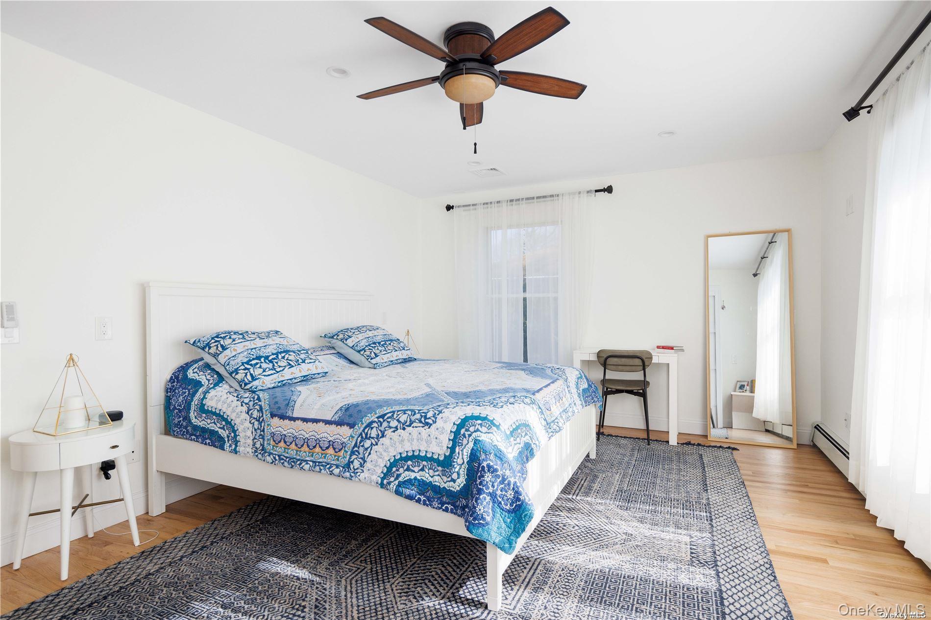 129 Lynncliff Road Hampton Bays, NY 11946 - Photo 7 of 19 a bedroom with a bed and a chandelier