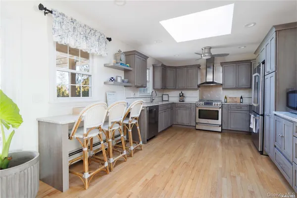 a kitchen with cabinets wooden floor and stainless steel appliances