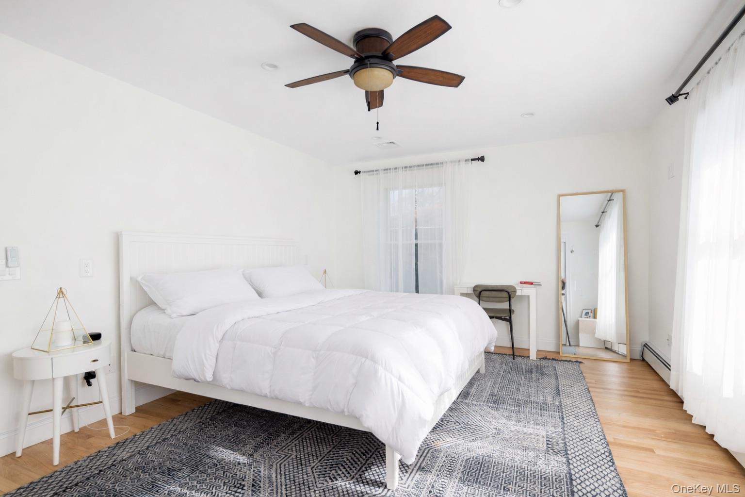 129 Lynncliff Road Hampton Bays, NY 11946 - Photo 9 of 24 a bedroom with a bed and a chandelier