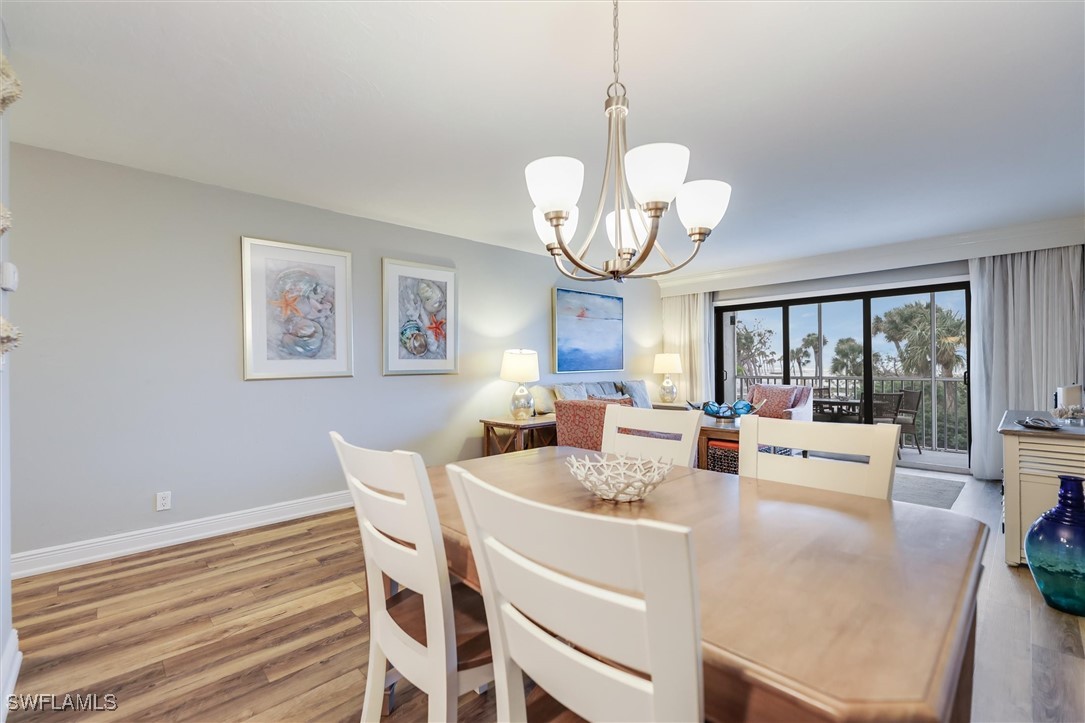 2117 Gulf Beach Villas Captiva, FL 33924 - Photo 10 of 24 a view of a dining room with furniture wooden floor and chandelier