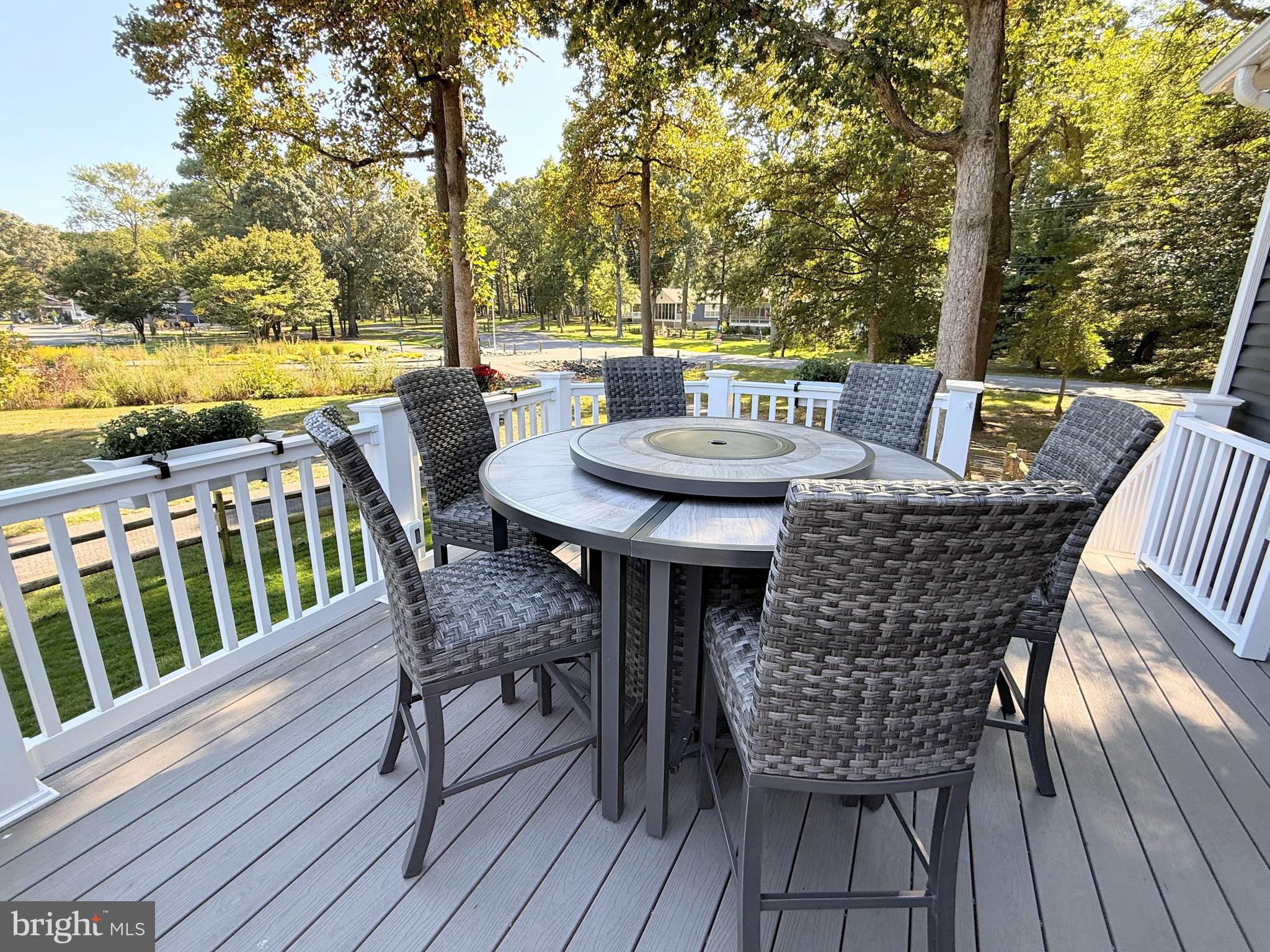 26908 Wood Duck Road, Unit 611 Long Neck, DE 19966 - Photo 12 of 80 a view of a dining table and chairs on the roof deck