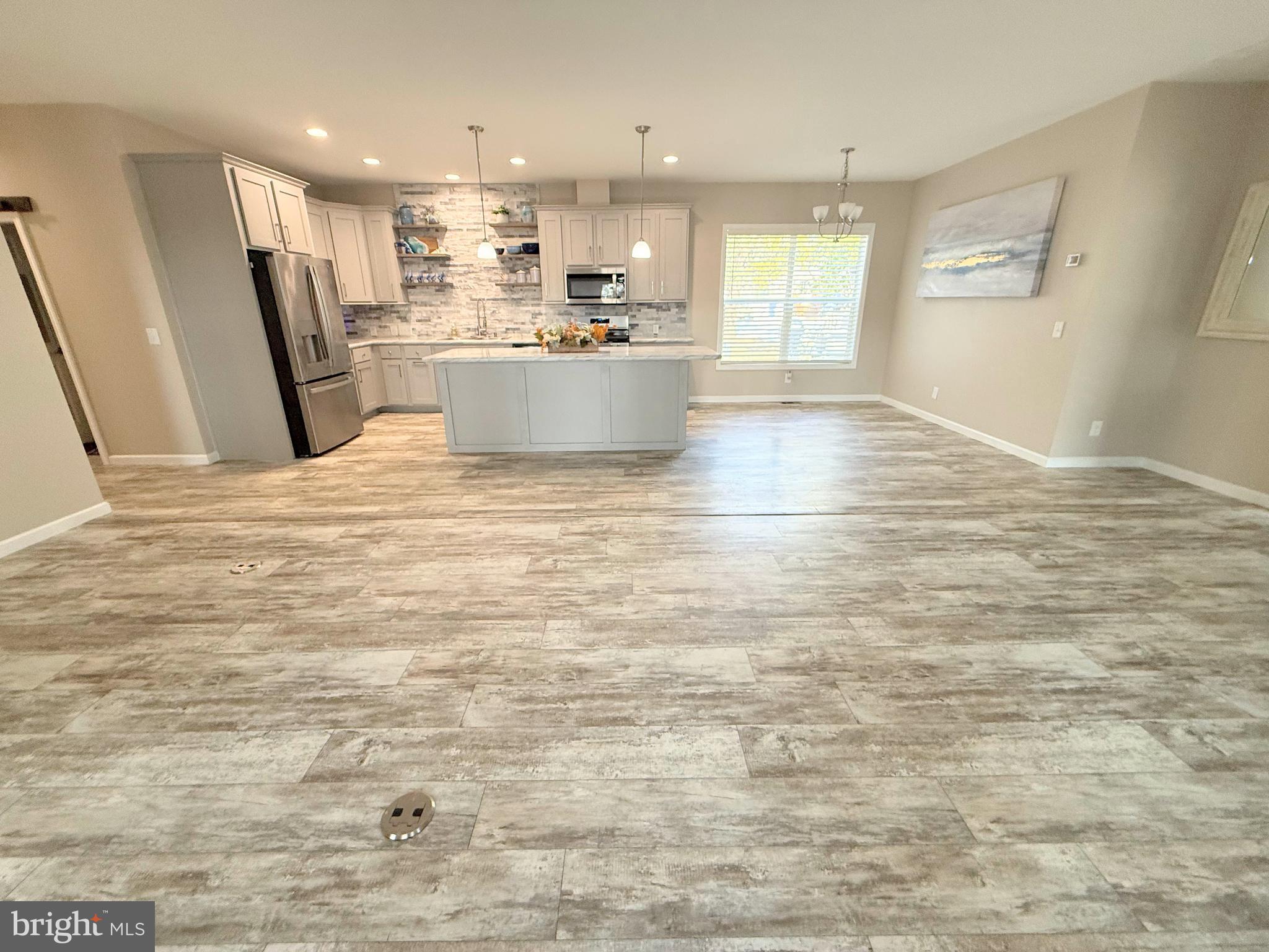 26908 Wood Duck Road, Unit 611 Long Neck, DE 19966 - Photo 22 of 80 a view of a kitchen with fridge and wooden floor
