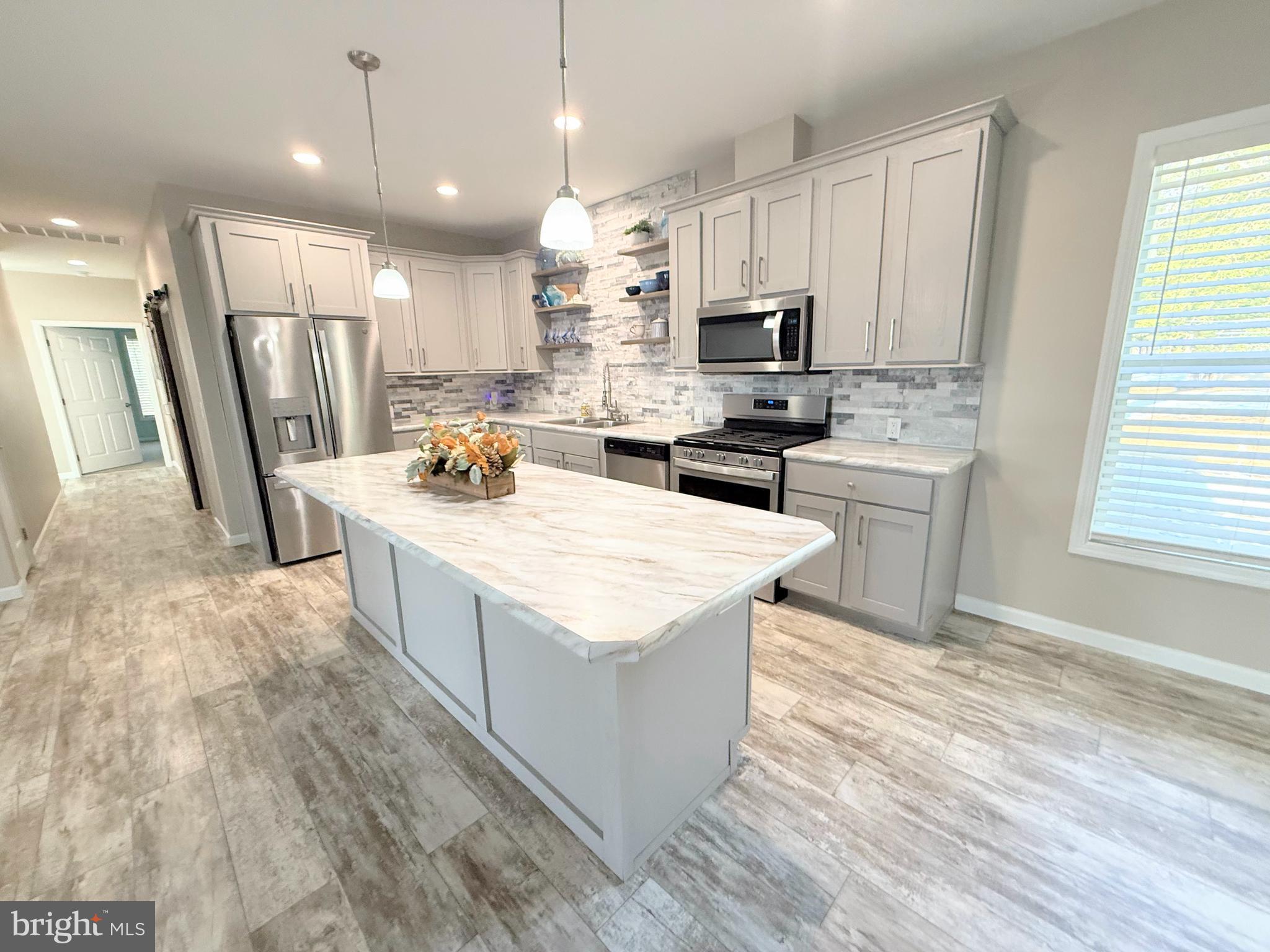 26908 Wood Duck Road, Unit 611 Long Neck, DE 19966 - Photo 24 of 80 a kitchen with granite countertop a sink a counter top space stainless steel appliances and cabinets