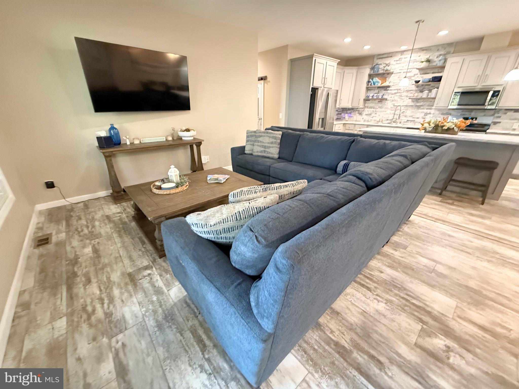 26908 Wood Duck Road, Unit 611 Long Neck, DE 19966 - Photo 26 of 80 a living room with furniture and a flat screen tv