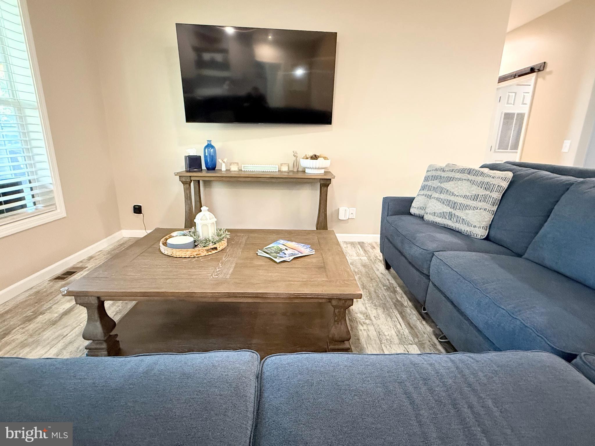 26908 Wood Duck Road, Unit 611 Long Neck, DE 19966 - Photo 28 of 80 a living room with furniture and a flat screen tv