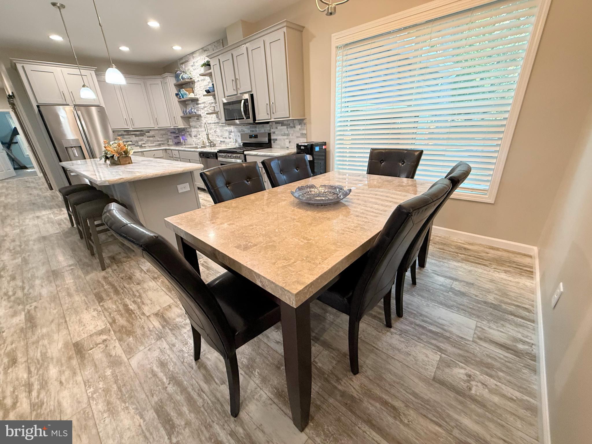 26908 Wood Duck Road, Unit 611 Long Neck, DE 19966 - Photo 31 of 80 a dining room with furniture and wooden floor