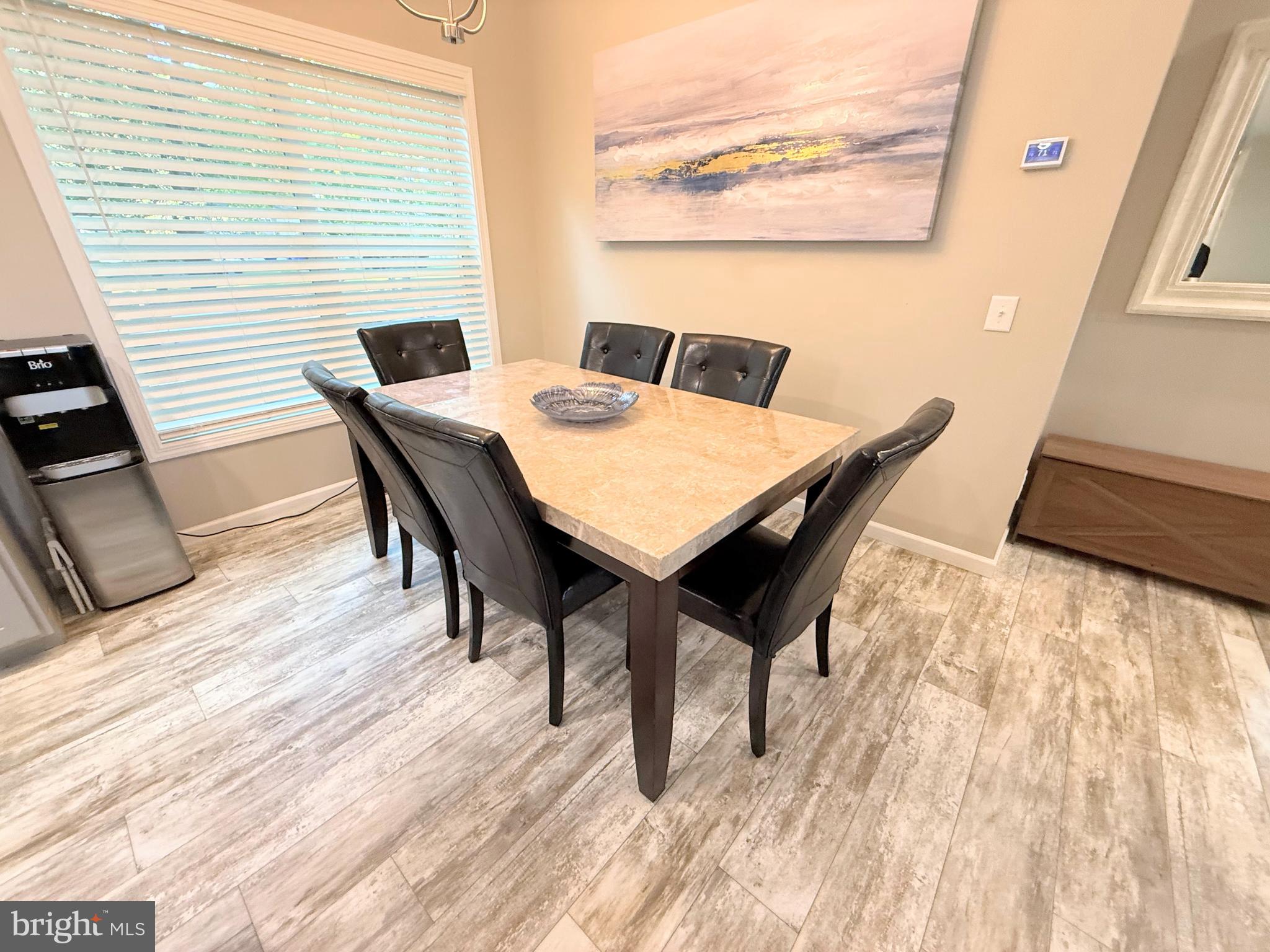 26908 Wood Duck Road, Unit 611 Long Neck, DE 19966 - Photo 32 of 80 a view of a dining room with furniture and wooden floor