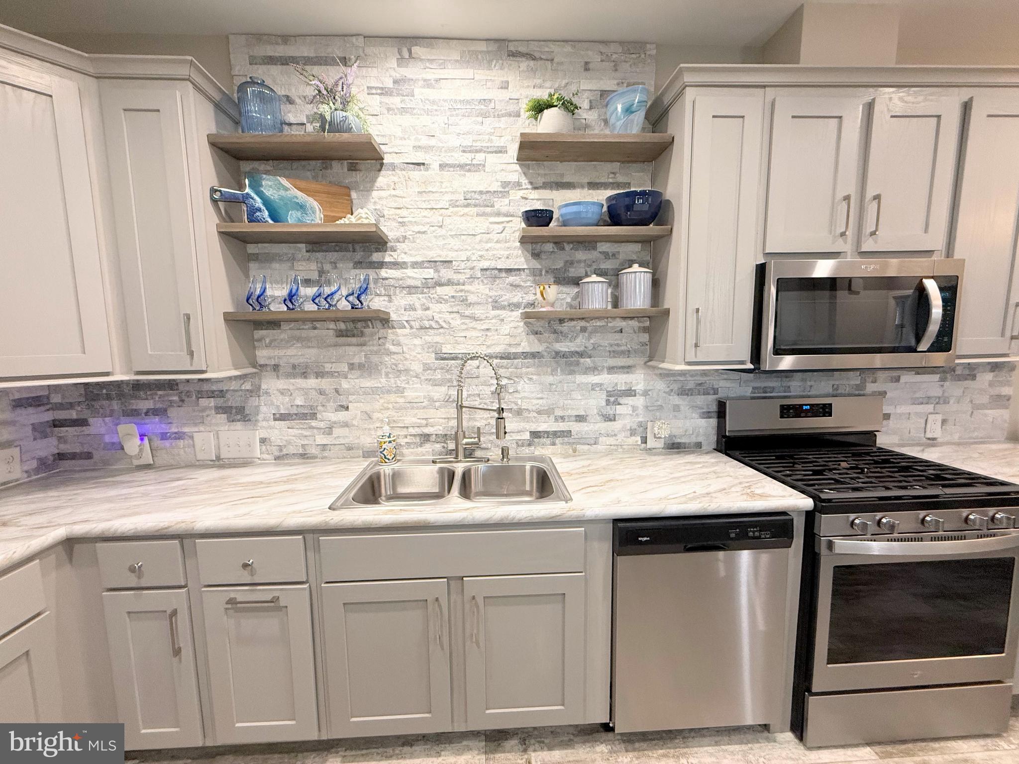 26908 Wood Duck Road, Unit 611 Long Neck, DE 19966 - Photo 38 of 80 a kitchen with stainless steel appliances granite countertop a sink stove and microwave