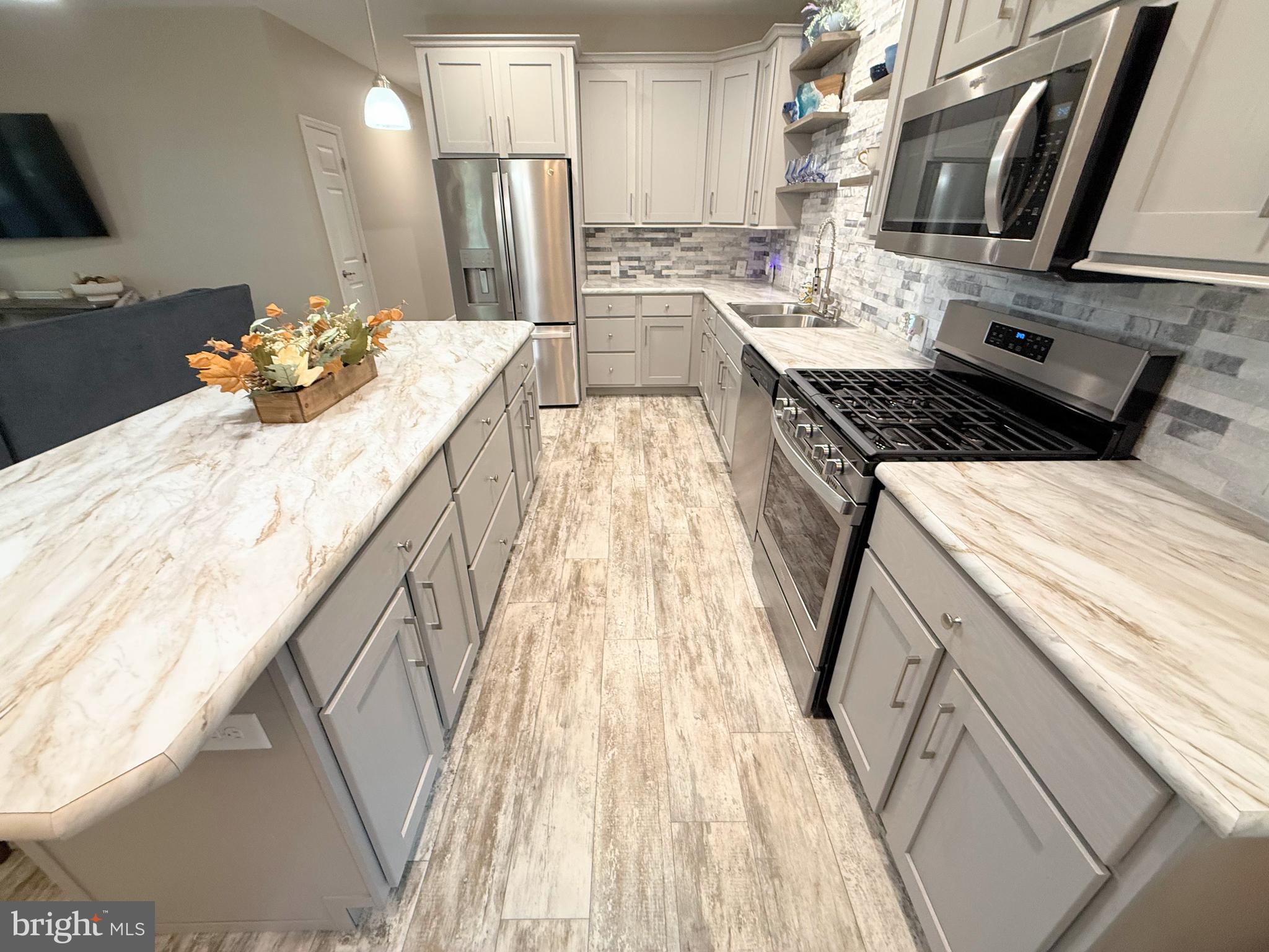 26908 Wood Duck Road, Unit 611 Long Neck, DE 19966 - Photo 39 of 80 a kitchen with sink stove and cabinets