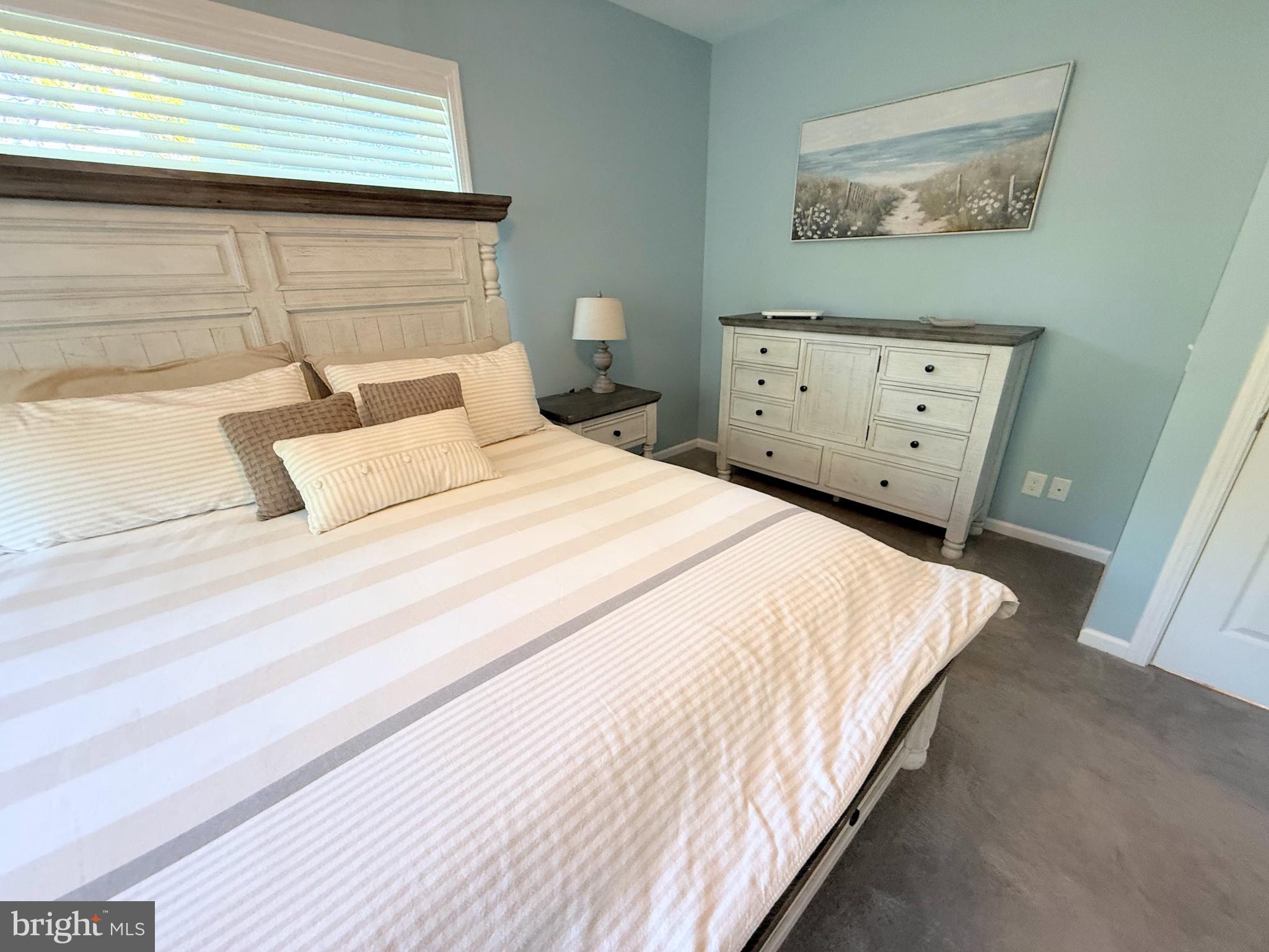 26908 Wood Duck Road, Unit 611 Long Neck, DE 19966 - Photo 44 of 80 a bedroom with a bed and painting on the wall
