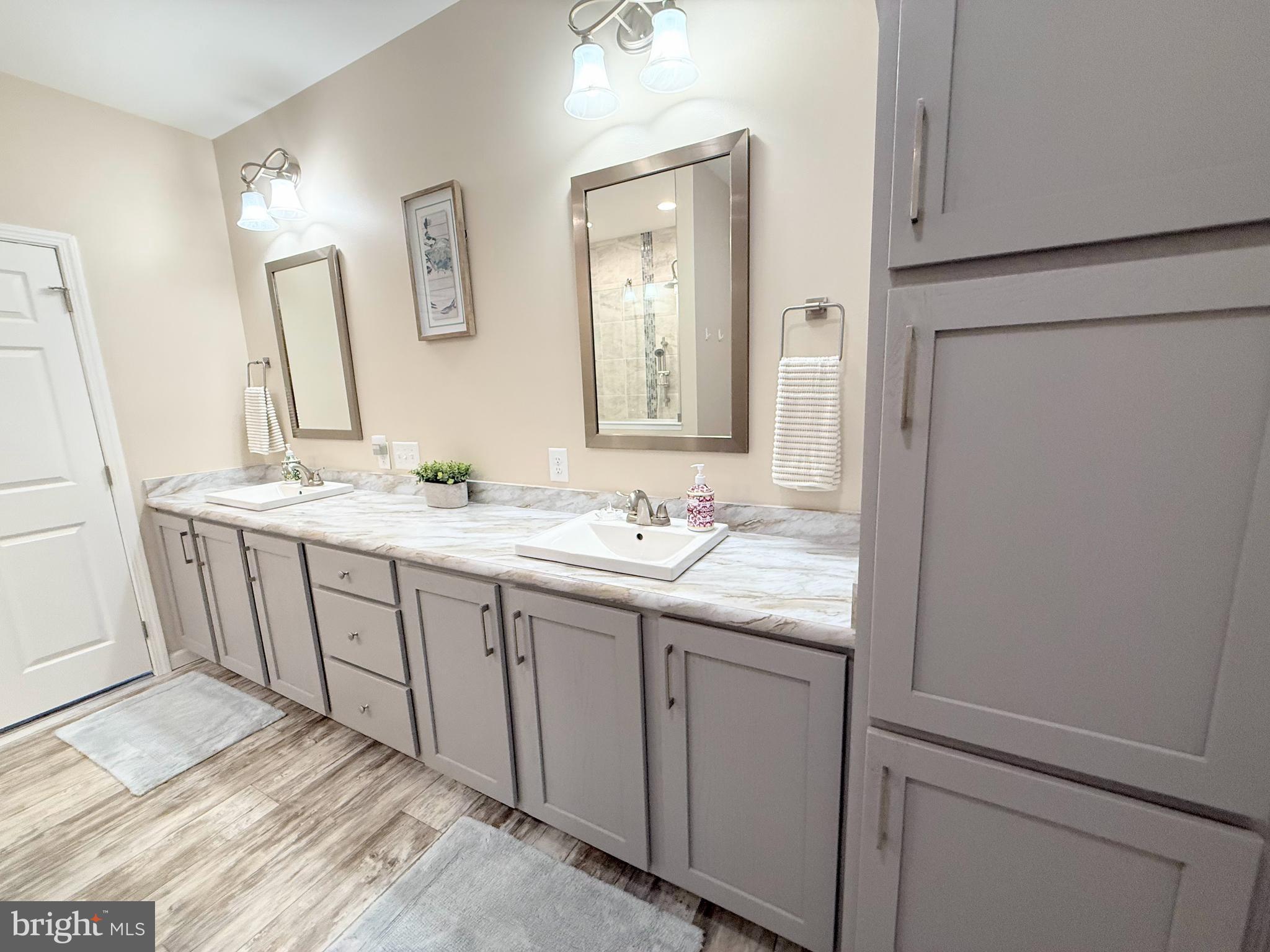26908 Wood Duck Road, Unit 611 Long Neck, DE 19966 - Photo 46 of 80 a bathroom with a granite countertop sink and a mirror