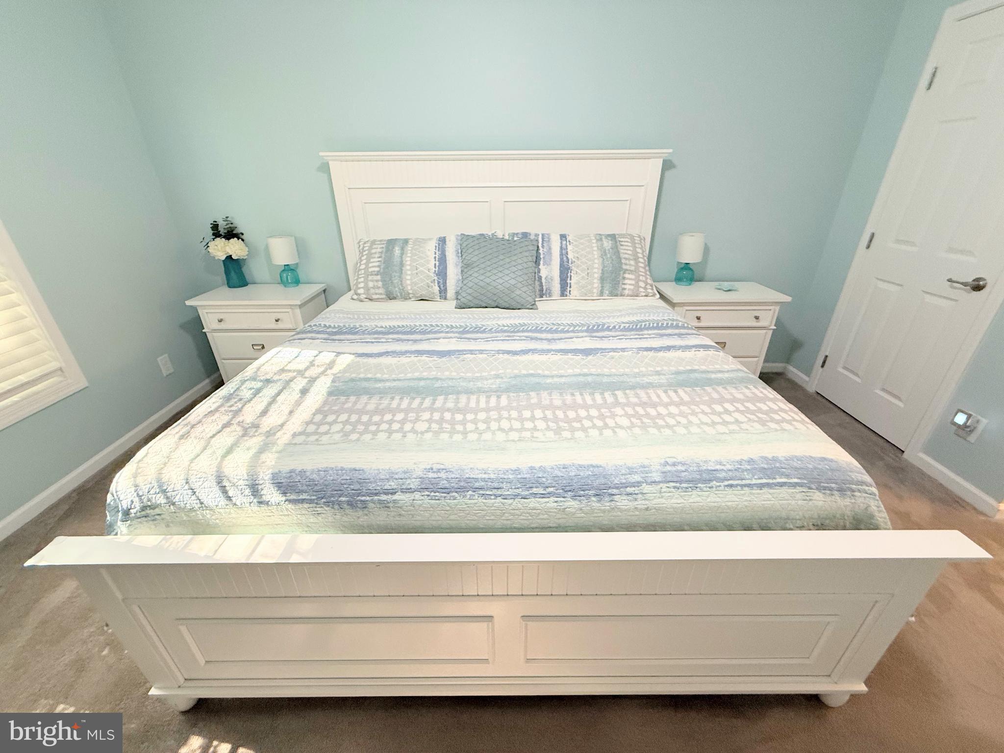 26908 Wood Duck Road, Unit 611 Long Neck, DE 19966 - Photo 52 of 80 a bedroom with a bed and wooden floor