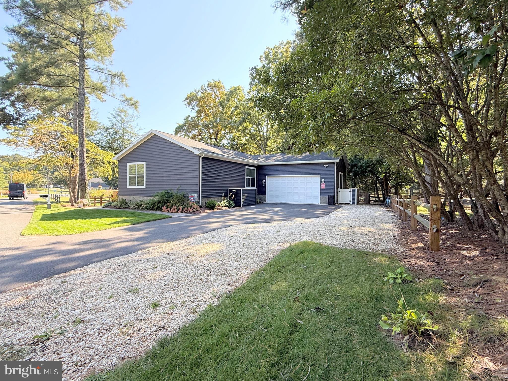 26908 Wood Duck Road, Unit 611 Long Neck, DE 19966 - Photo 72 of 80 a view of a house with a big yard and large trees
