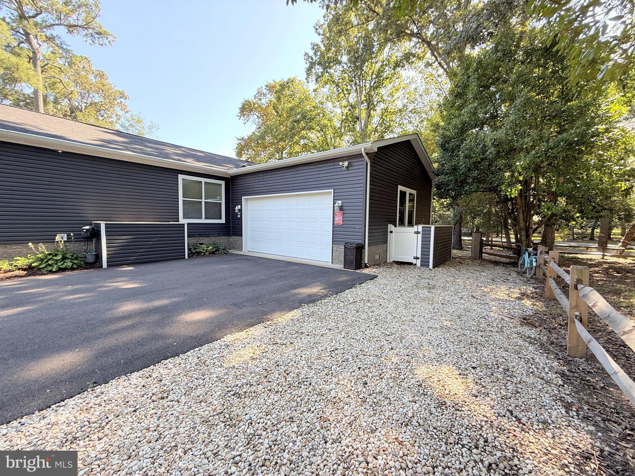26908 Wood Duck Road, Unit 611 Long Neck, DE 19966 - Photo 73 of 80 a front view of a house with a yard and garage