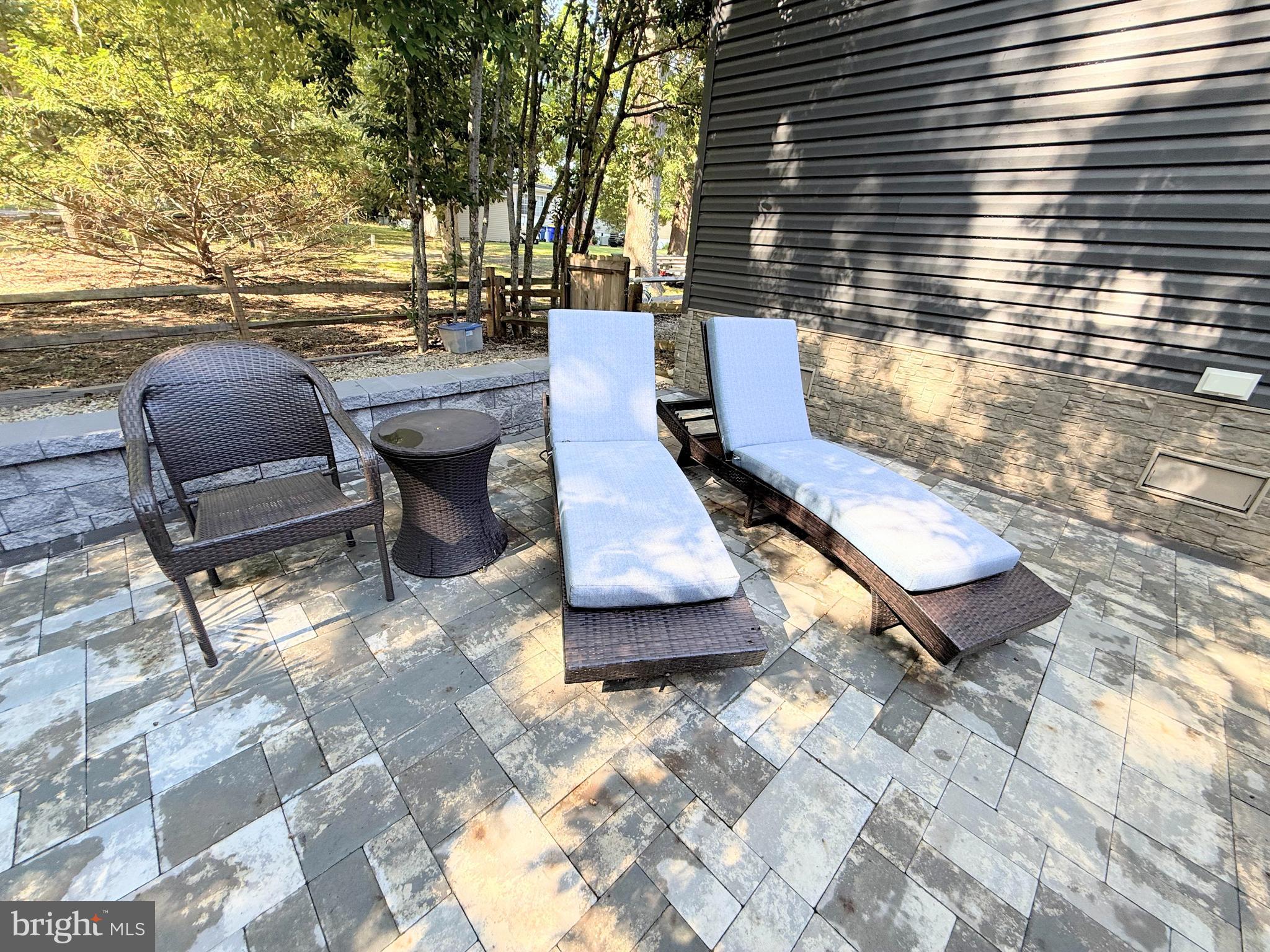 26908 Wood Duck Road, Unit 611 Long Neck, DE 19966 - Photo 75 of 80 a view of a patio with table and chairs with wooden floor and fence