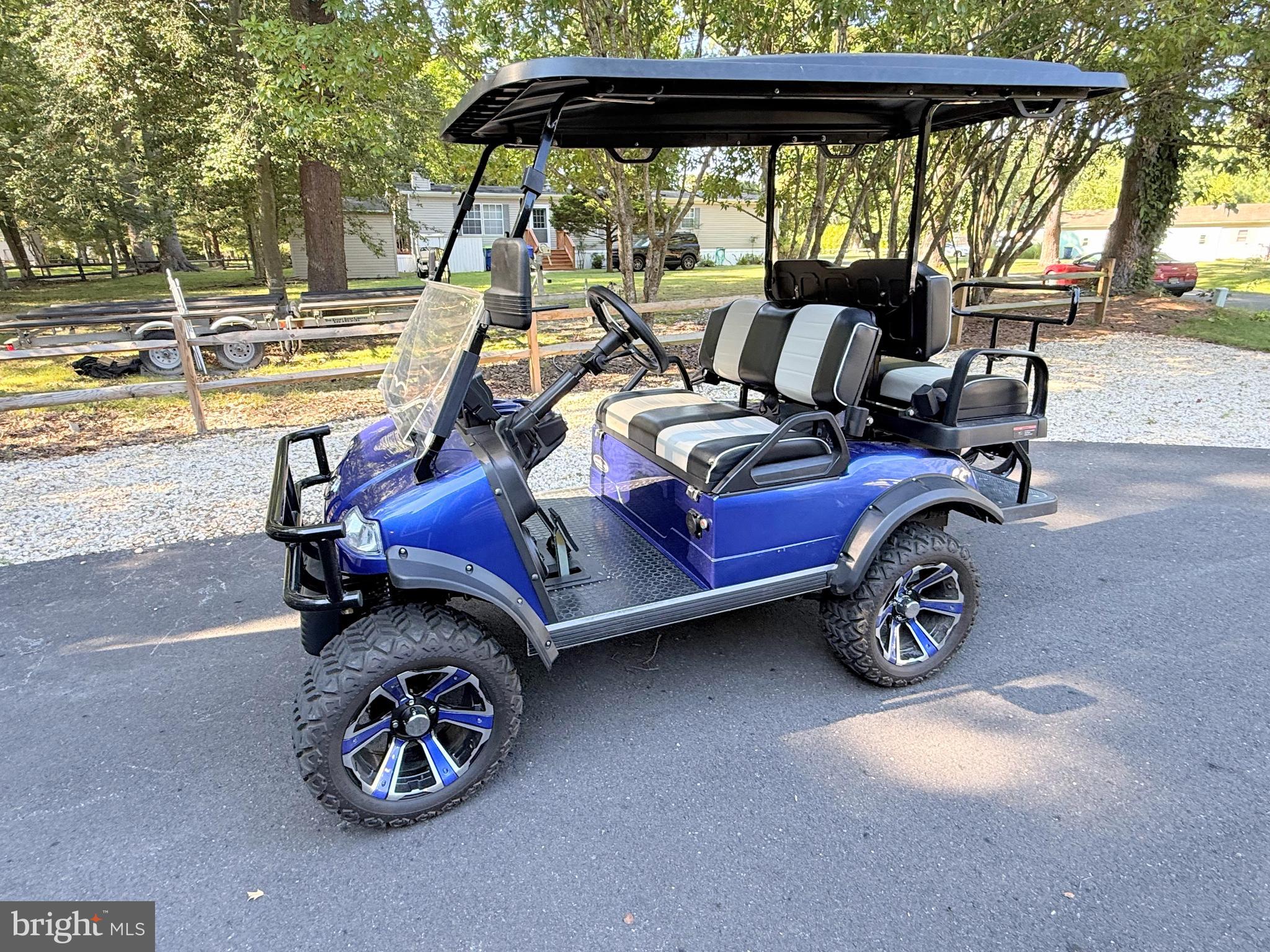 26908 Wood Duck Road, Unit 611 Long Neck, DE 19966 - Photo 77 of 80 a view of a patio with table and chairs under an umbrella with a small yard