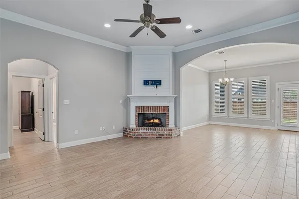 wooden floor fireplace and windows in an empty room