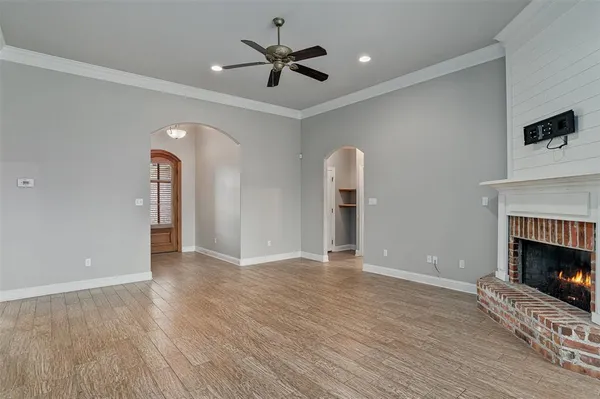 an empty room with fan and wooden floor