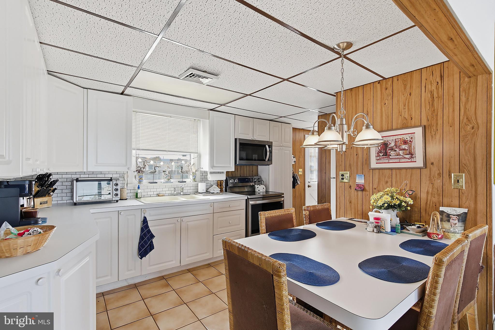 329 West 5th Street Ship Bottom, NJ 08008 - Photo 11 of 47 a kitchen with a sink a stove and chairs