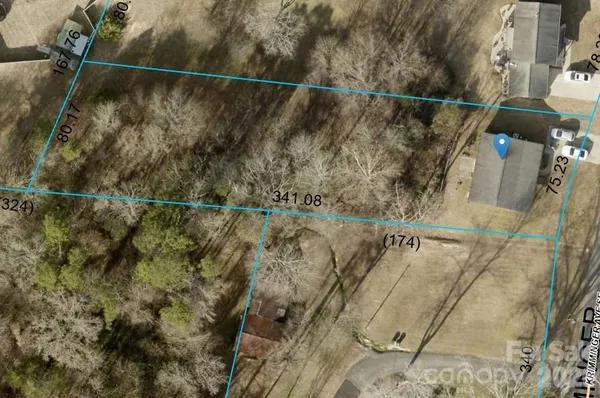 an empty room with chandelier fan and windows