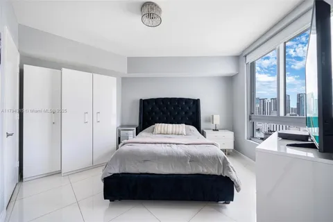 a bedroom with a bed and flat screen tv