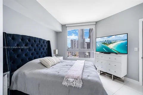 a bedroom with a bed and a flat screen tv