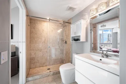 a spacious bathroom with a bathtub shower sink mirror and toilet