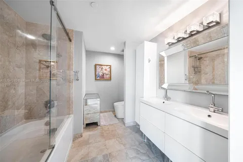 a en suite spacious bathroom with a double vanity sink a large mirror and shower