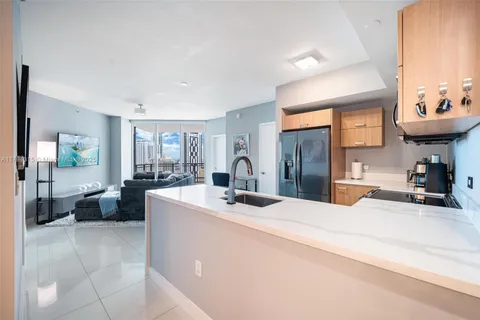 a kitchen with stainless steel appliances a sink a stove top oven a counter top space and cabinets