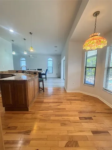 a view of a kitchen with kitchen island a sink stainless steel appliances and a chandelier