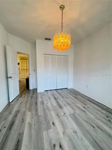 a view of empty room with wooden floor and window