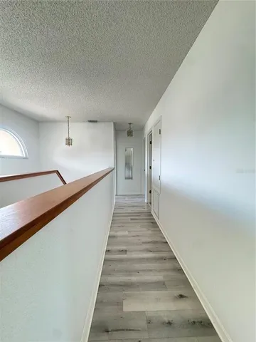 an empty room with windows and ceiling fan