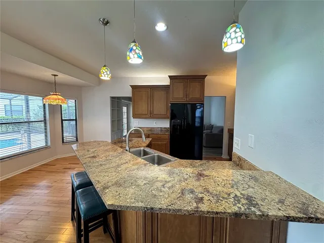 a kitchen with stainless steel appliances granite countertop a sink refrigerator and microwave