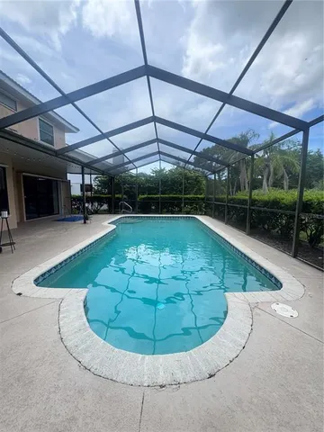 a view of a swimming pool with a patio and a yard