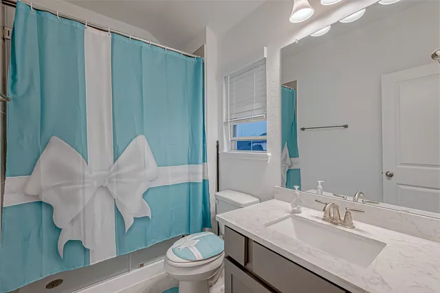 a view of an empty room and chandelier fan