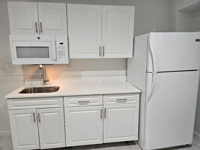 a kitchen with cabinets and white stainless steel appliances