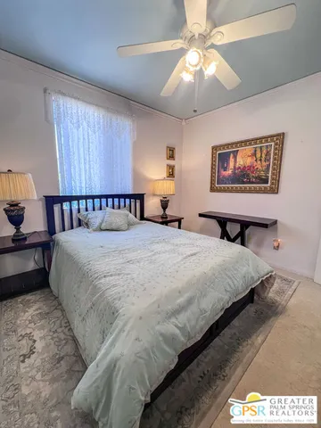 a bedroom with a bed and a painting on the wall