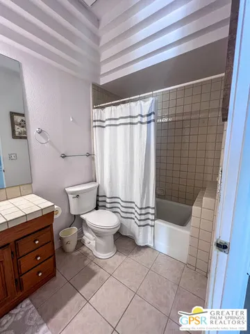 a bathroom with a sink a toilet a mirror and shower
