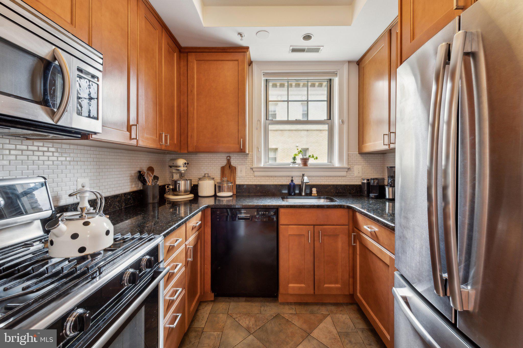 3220 17th Street Northwest, Unit 309 Washington, DC 20010 - Photo 12 of 25 a kitchen with stainless steel appliances granite countertop a stove sink and cabinets
