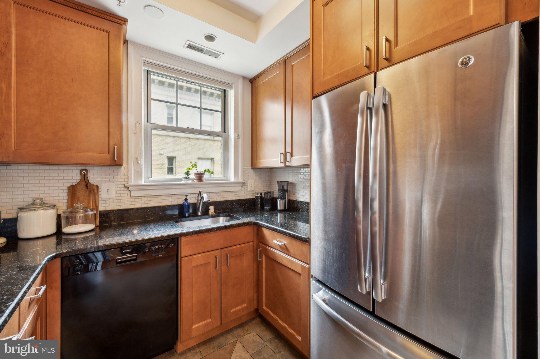3220 17th Street Northwest, Unit 309 Washington, DC 20010 - Photo 13 of 25 a kitchen with stainless steel appliances granite countertop a refrigerator a sink and white cabinets