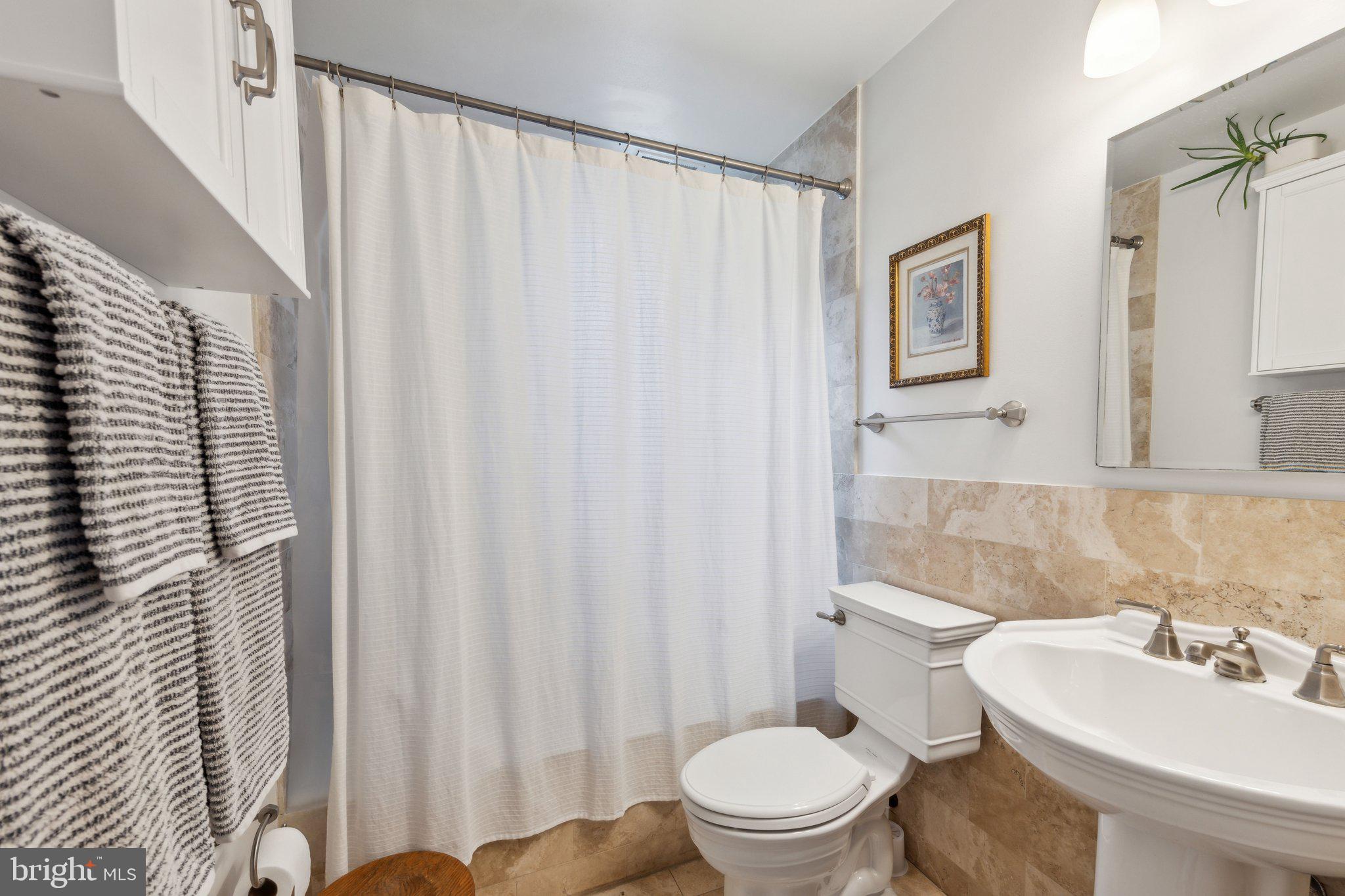 3220 17th Street Northwest, Unit 309 Washington, DC 20010 - Photo 18 of 25 a bathroom with a sink a toilet and shower curtain