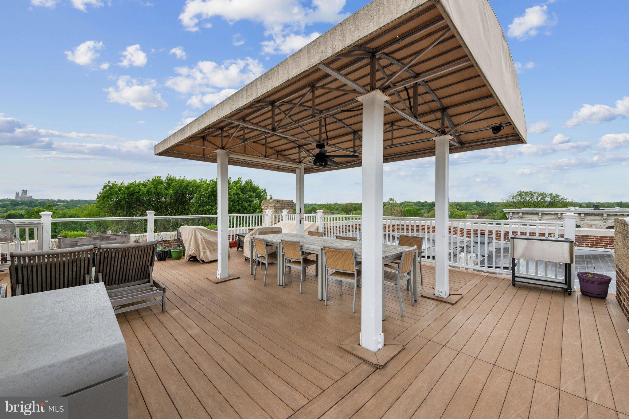3220 17th Street Northwest, Unit 309 Washington, DC 20010 - Photo 21 of 25 a view of a roof deck with table and chairs couches with wooden floor and fence