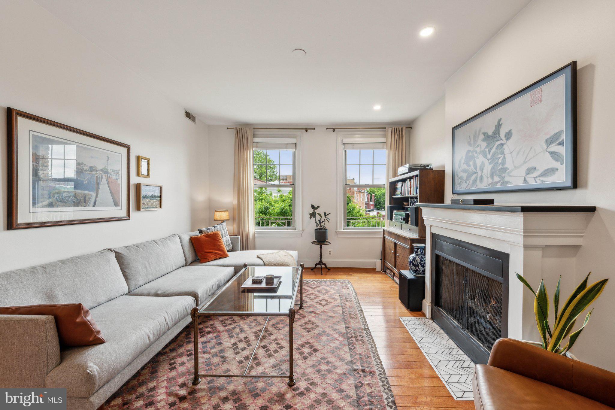 3220 17th Street Northwest, Unit 309 Washington, DC 20010 - Photo 8 of 25 a living room with furniture a fireplace and a large window