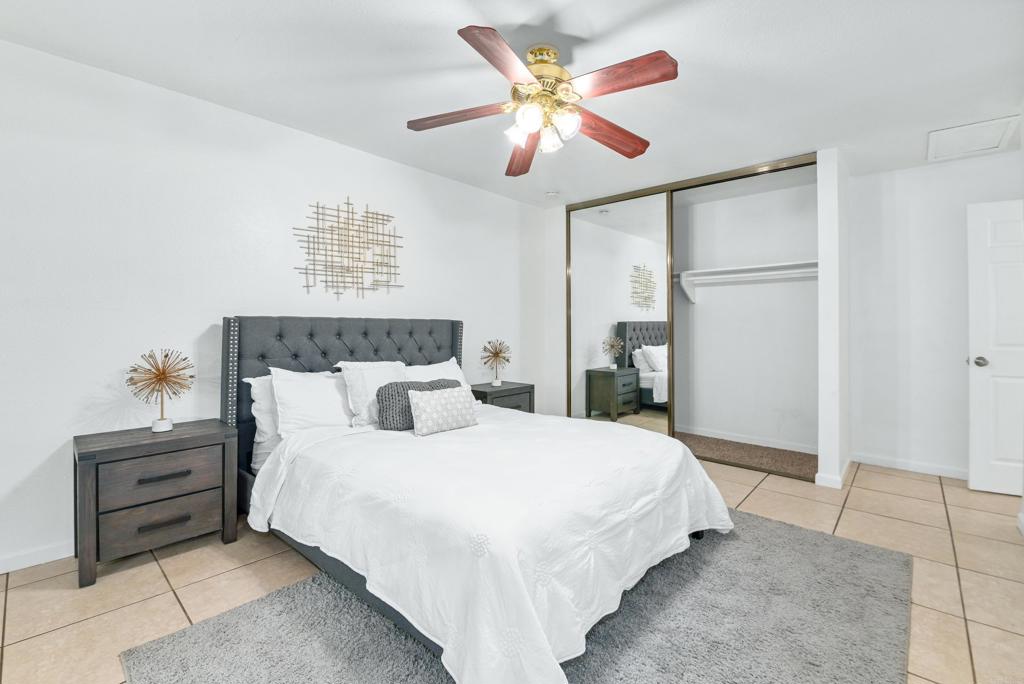 514 Shady Lane, Unit C El Cajon, CA 92021 - Photo 18 of 30 a bedroom with a large bed and a chandelier