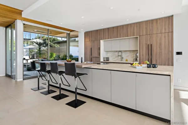 a dining hall with stainless steel appliances granite countertop a stove a sink and a refrigerator