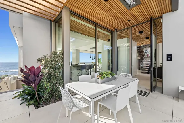 a dining room with furniture and a floor to ceiling window
