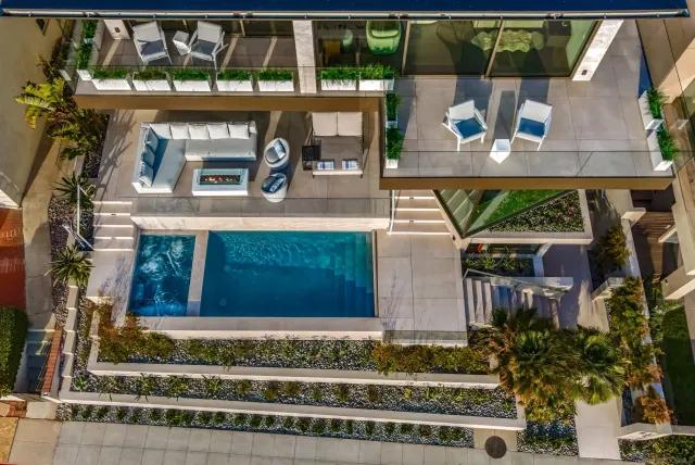 a view of a patio with table and chairs potted plants and floor to ceiling window