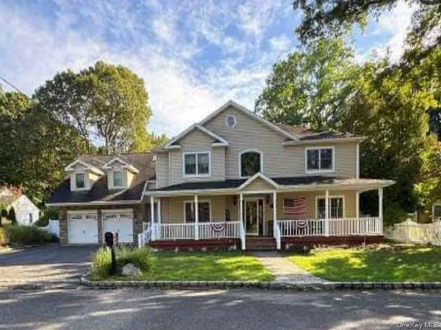 a view of a white house with large windows and a yard in front of it